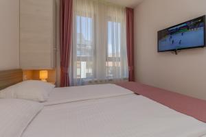 ズラティボールにあるTime Out Wine apartmanのベッドルーム1室(大型ベッド1台、壁掛けテレビ付)
