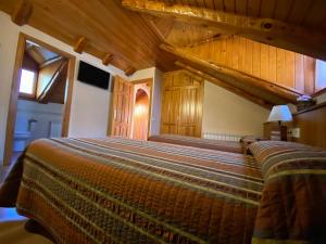 een slaapkamer met een groot bed en houten plafonds bij Casa Torellola in Cardet