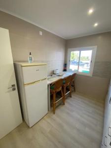 a kitchen with a refrigerator and a table with chairs at Monte Gordo apartment in Monte Gordo