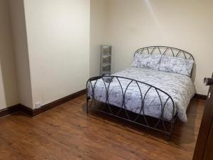 1 dormitorio con 1 cama y suelo de madera en 3/4 Bedroom House, en Mánchester