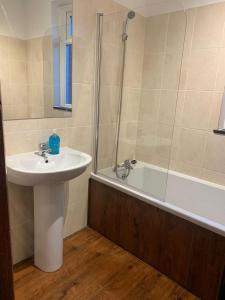 a bathroom with a sink and a shower and a tub at 3/4 Bedroom House in Manchester