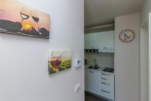 ズラティボールにあるTime Out Wine apartmanの白いキャビネットと壁掛け時計付きのキッチン +7枚の写真