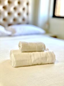 duas toalhas sentadas em cima de uma cama em 02 QUARTOS, a 100 metros da PRAIA de PAJUÇARA em Maceió