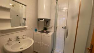 un bagno bianco con lavandino e doccia di Horský apartmán ROKY - Krkonoše a Rokytnice nad Jizerou Altre 44 foto