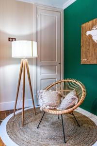 a wicker chair sitting on a rug next to a lamp at Les Antiquaires #CQ in Grenoble