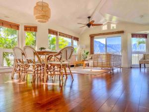 a dining room with a table and chairs and windows at Villas of Kamali'i Mountain Waterfall Views in Princeville