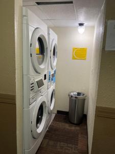 a hallway with two washing machines in a room at Super 8 by Wyndham Bismarck in Bismarck