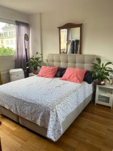 een slaapkamer met een groot bed met rode kussens bij Top Place in Genève