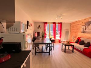a living room with a couch and a table in it at T2 ensoleillé. Terrasse et vaste jardin commun in Cauterets +14 photos