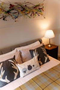 ein Bett mit Kissen und ein Gemälde an der Wand in der Unterkunft Riverside West End Apartment in Glasgow