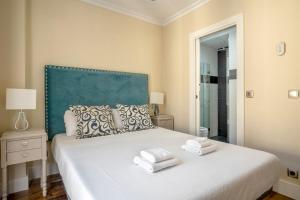 a bedroom with a large white bed with towels on it at Minty Stay - Plaza Mayor 3 BD in Madrid