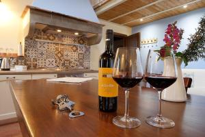butelkę wina i dwa kieliszki na stole w obiekcie Podere San Giuseppe w mieście San Vincenzo