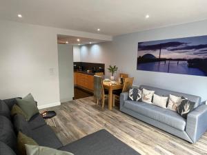 uma sala de estar com um sofá e uma mesa em Riverside West End Apartment em Glasgow