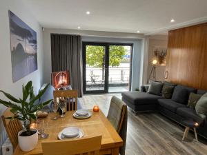 uma sala de estar com uma mesa e uma sala de estar com um sofá em Riverside West End Apartment em Glasgow