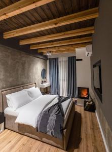 a bedroom with a large bed and a fireplace at Bujtina Oxhaku in Korçë