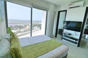 a bedroom with a bed and a large window at Moderno 3 Alcobas Frente a Playa in Cartagena de Indias