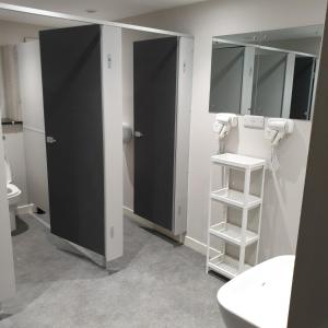 a bathroom with two black stalls and a sink at JUST SLEEP Hostel in Edinburgh