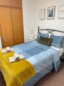ein großes blaues Bett mit Handtüchern darüber in der Unterkunft UIM Mediterraneo Diagonal 16 Wfi in Puerto de Sagunto
