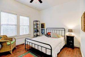um quarto com uma cama, uma cadeira e janelas em Artsy Heights House: Walk To Food-Bars-Shops-Trails, Kids & Pet Friendly em Houston