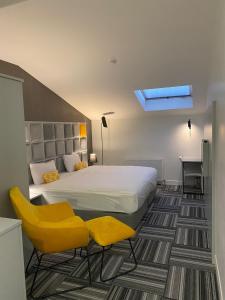 a bedroom with a bed and two yellow chairs at Continent Luxury Suites Sakarya in Sakarya
