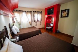 a hotel room with two beds and a red wall at Hotel D&rsquo;Monica in San Crist&oacute;bal de Las Casas
