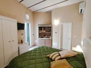 a bedroom with a green bed with two pillows at La Capasa di CasAda in Spongano