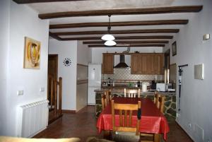 cocina y comedor con mesa y sillas en Cruzchiquita, en Alpandeire
