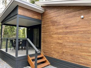 a house with a wooden wall and a deck at Levi Adelaide Holiday Park in Adelaide