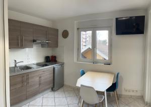 a kitchen with a table and chairs and a window at le Rialto **** : cozy T2 avec parking / v-rent in Annecy