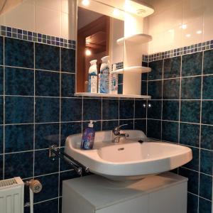 La salle de bains est pourvue d'un lavabo et d'un miroir. dans l'établissement Gästehaus Mia, à Norddeich