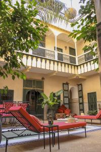 a patio with chairs and tables and a building at Riad Dar Habiba by Garden Wonders in Marrakech