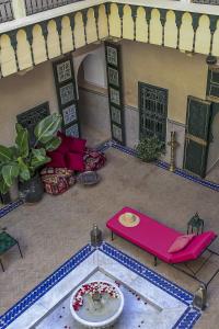 sala de estar con sofá rosa y mesa en Riad Dar Habiba by Garden Wonders, en Marrakech