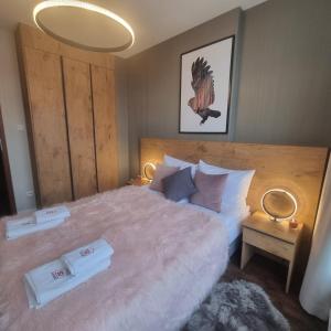 een slaapkamer met een groot bed en 2 handdoeken bij Apartament SPA 56 Resort Kozubnik blisko Szczyrk - 5D Apartamenty in Porąbka