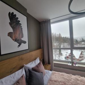 a bedroom with a bed and a large window at Apartament SPA 56 Resort Kozubnik blisko Szczyrk - 5D Apartamenty in Porąbka