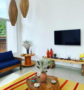 a living room with a blue couch and a tv at Casa Beija Flor in Porto Seguro