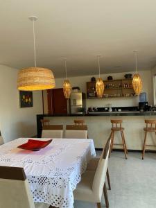 a kitchen with a table and chairs and lights at Casa Beija Flor in Porto Seguro