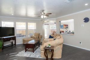 uma sala de estar com um sofá e uma televisão de ecrã plano em Cozy Home - Self Check-In w/Spacious Deck em San Antonio