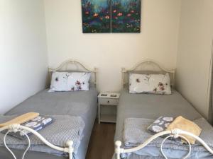 two twin beds in a room with a table at Manly Waterfront Beach Stay in Queenscliff