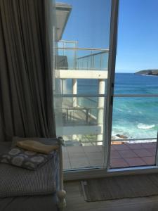 a room with a window with a view of the ocean at Manly Waterfront Beach Stay in Queenscliff