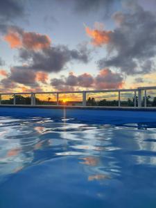uma vista para o pôr-do-sol a partir de uma piscina em Studio Moah 205_Porto de Galinhas em Porto de Galinhas