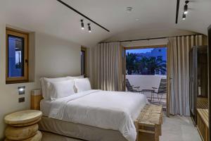 卡马利Radisson Blu Zaffron Resort, Santorini的一间带大床的卧室和一个阳台