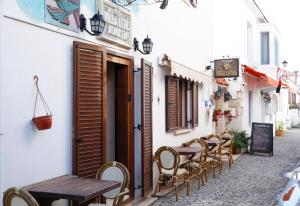 an alley with tables and chairs on a street at villa lotus butik otel in Seferihisar