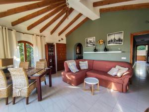 sala de estar con sofá rojo y mesa en villa Anastasia, en Cumbre del Sol