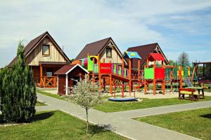 un parque infantil frente a una casa con en Holiday home in Ustronie Morskie with a playground en Ustronie Morskie