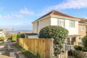 a house with a fence in front of it at Pengullyn in Penzance