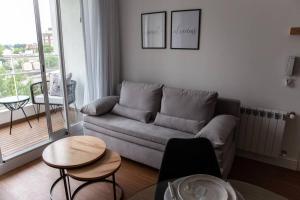 a living room with a couch and tables and a balcony at Sweet Dreams I in Junín