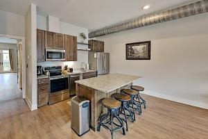 una cucina con bancone e sgabelli di Haywood Chic Retreat Unit 215 ad Asheville