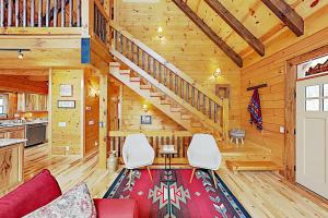 una sala de estar con una escalera en una cabaña de madera en Tenderfoot Lodge, en Maggie Valley