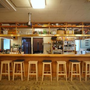 a bar with wooden stools in a kitchen at La Union ラウニオン in Fukushima