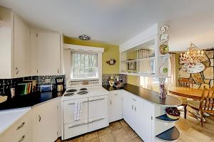 a kitchen with white cabinets and a white stove top oven at Vintner's Cottage in Hendersonville